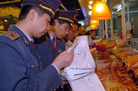 图文:执法人员在超市检查肉制品检疫证明